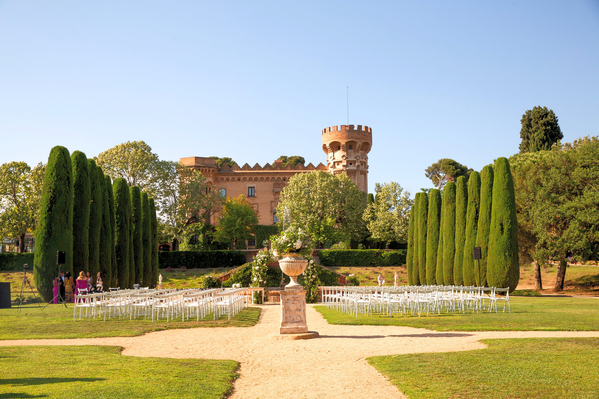 Wedding ceremony in a castle garden with cypress trees