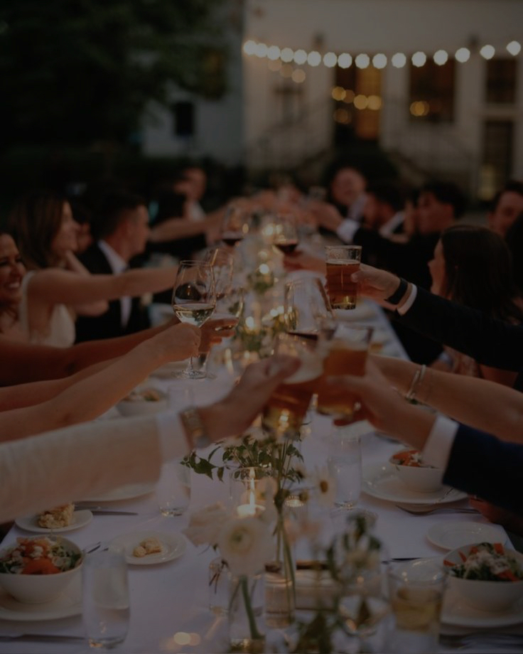 Convidados brindando em uma mesa longa iluminada por velas na Espanha